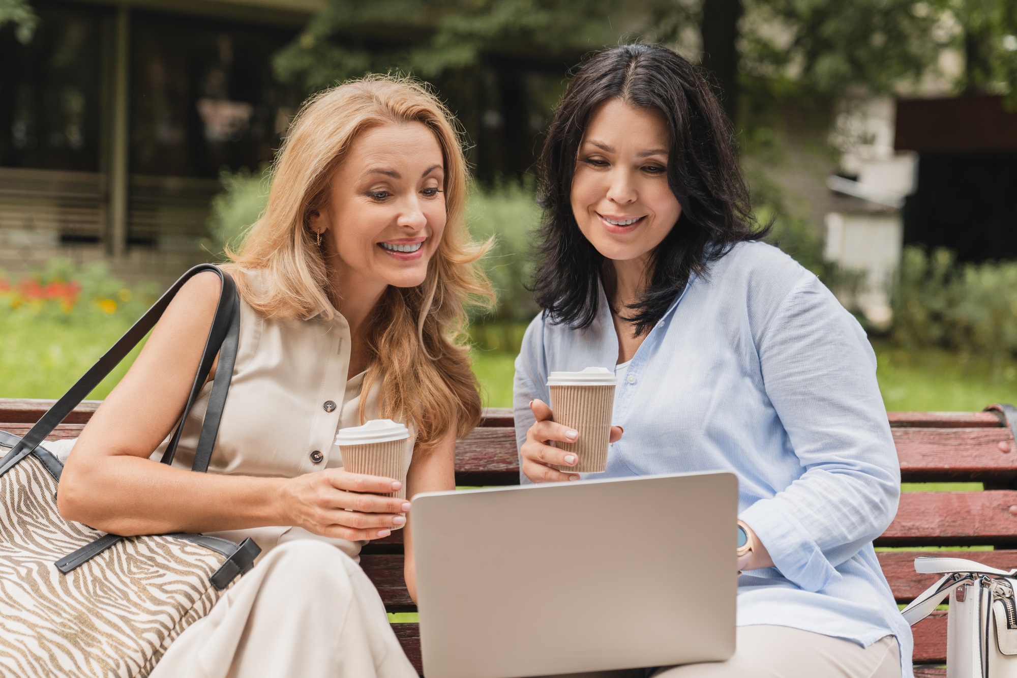 Two middle-aged mature women sisters best friends girlfriends watching movie webinar